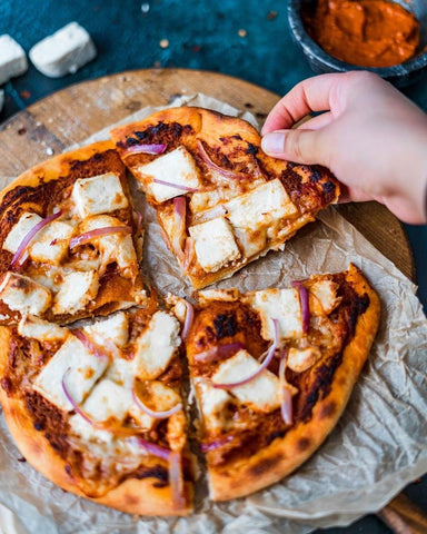 hand taking a slice of pizza 